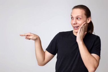 Siyah tişörtlü, şaşkın bir genç parmak uzatıyordu.