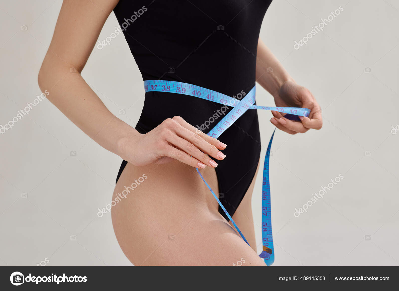 Woman Body with a Tape Measure Measuring Her Waist Stock Photo