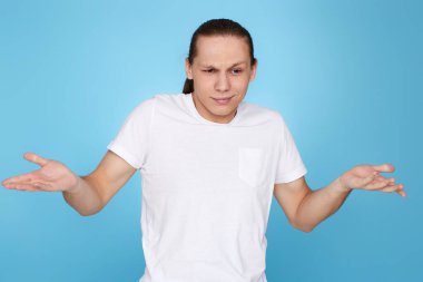 Tişörtlü, yüzünde şüphe olan yakışıklı bir adam.