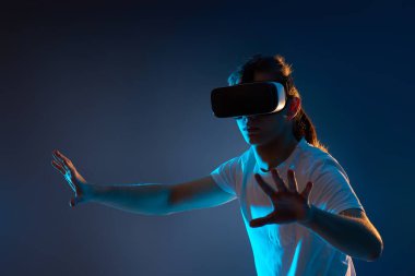 Genç adam sanal gerçeklik kulaklığı kullanıyor. VR aygıtları