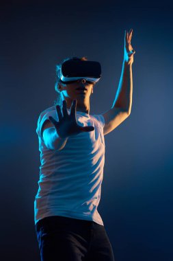 Genç adam sanal gerçeklik kulaklığı kullanıyor. VR aygıtları