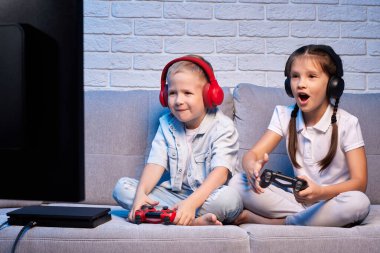 Oyun konsoluyla oyun oynayan çocuklar