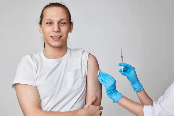 Joven durante la vacunación contra el coronavirus, inmunización con covid-19. —  Fotos de Stock