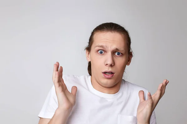 Hombre asustado en camiseta aislado sobre fondo gris. —  Fotos de Stock