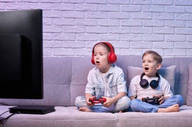 Oyun konsoluyla oyun oynayan çocuklar