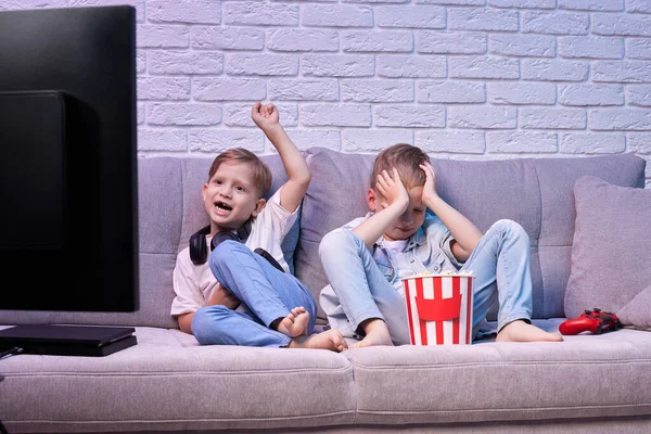 Oyun konsoluyla oyun oynayan çocuklar