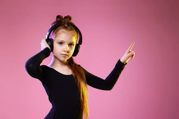 Dziewczynka w okularach przeciwsłonecznych i słuchawkach słuchających muzyki — Zdjęcie stockowe