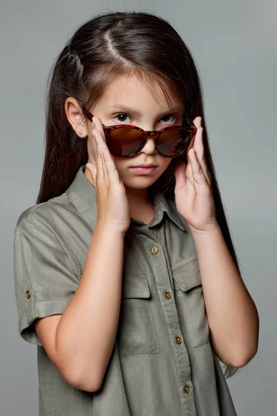 Cute little child girl in sunglasses on gray background — Stock Photo, Image