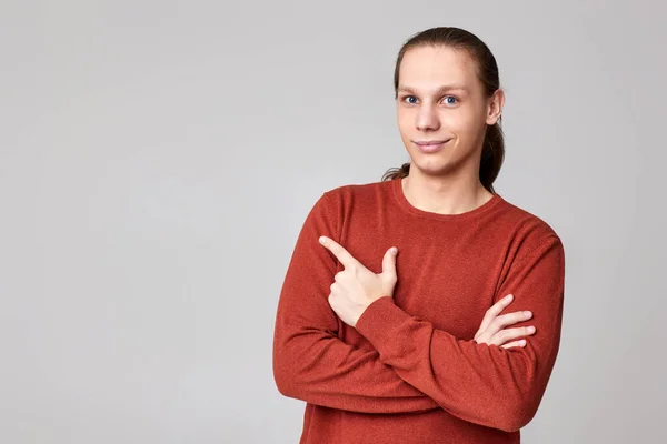 Young man pointing finger away at empty space — Stock Photo, Image