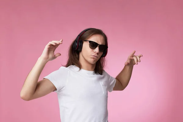 Человек в солнцезащитных очках слушает музыку в наушниках и танцах — стоковое фото
