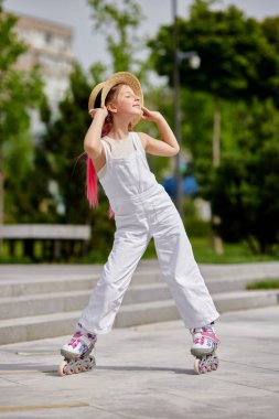 Saçı örgülü, patenli neşeli küçük kız.