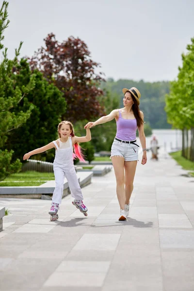 Roodharige kleine meisje leert rolschaatsen — Stockfoto