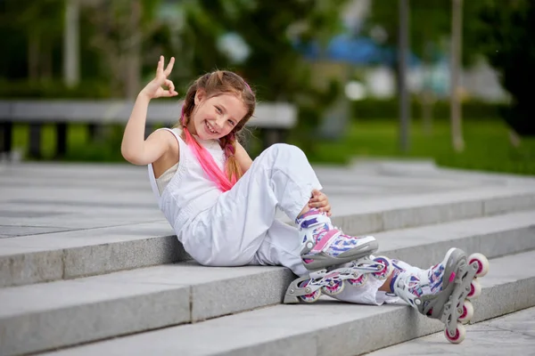 Cute little girl na wrotkach w parku. — Zdjęcie stockowe