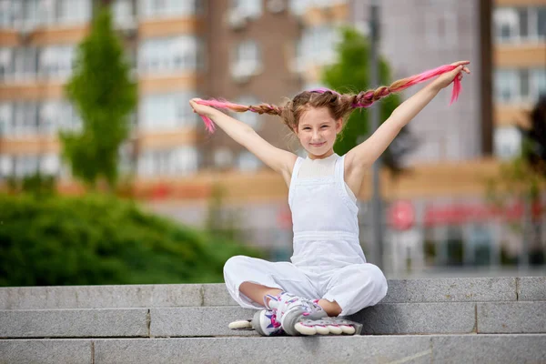 Schattig klein meisje op rolschaatsen in park. — Stockfoto