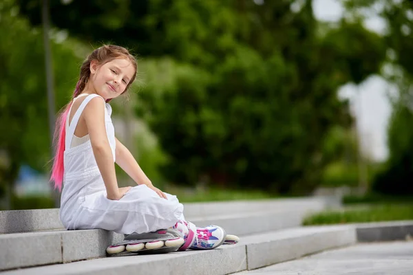 Cute little girl na wrotkach w parku. — Zdjęcie stockowe