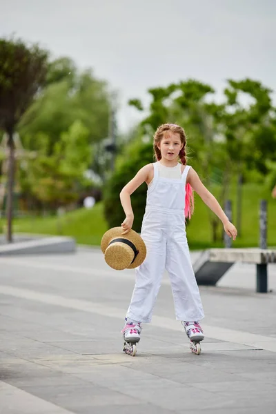 Cute little child girl on roller skates at park — Stock Photo, Image