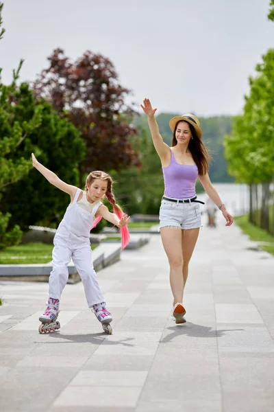 Roodharige kleine meisje leert rolschaatsen — Stockfoto