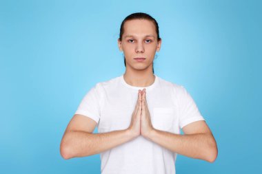 Sakin adam yoga jestinde el ele tutuşuyor.