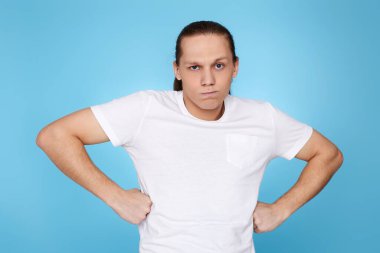 Genç adam mavi arka planda soyutlandı.