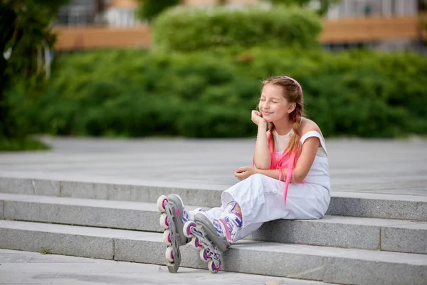 Roztomilá holčička na kolečkových bruslích v parku. — Stock fotografie