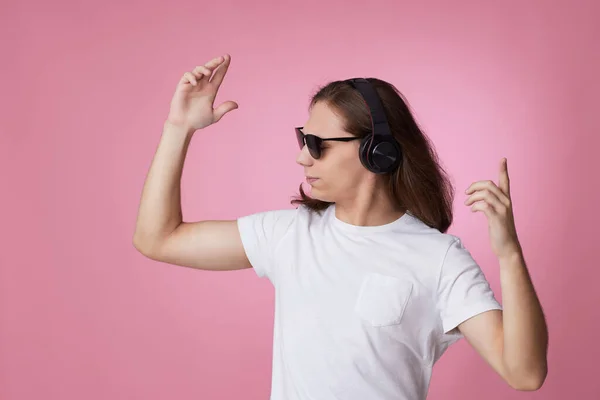 Férfi napszemüvegben zenét hallgat fejhallgatóval és tánccal — Stock Fotó