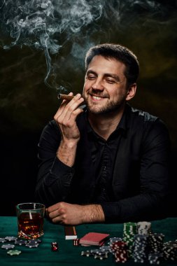 Yeşil masada poker oynayan sakallı kumarbaz.