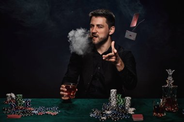 Yeşil masada poker oynayan sakallı kumarbaz.