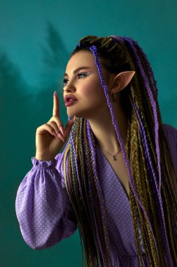 Genç ve güzel kadın elf kameraya poz veriyor.