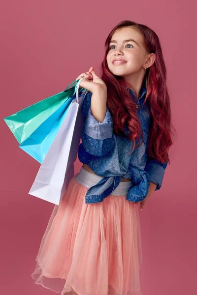 Маленька біла дівчинка тримає сумки для покупок — стокове фото