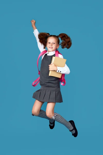 Cute happy schoolgirl jumping up with backpack — Stock Photo, Image