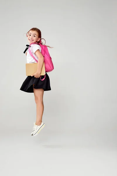 Linda colegiala feliz saltando con la mochila — Foto de Stock