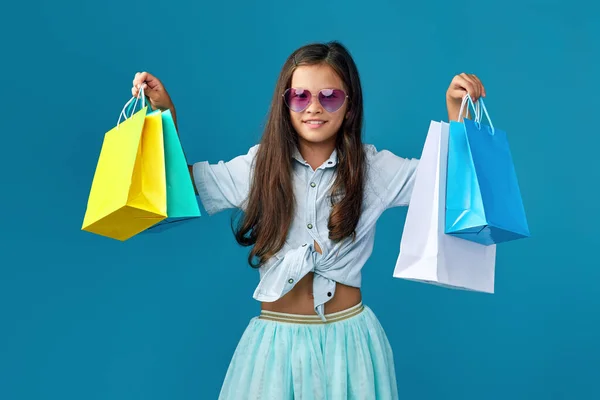많은 쇼핑백을 들고 있는 행복 한 꼬마 코카서스 소녀 — 스톡 사진