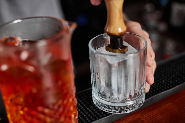 Barman en delantal vierte cóctel a la antigua en vidrio —  Fotos de Stock