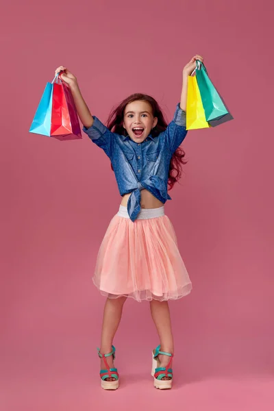 Маленька біла дівчинка тримає сумки для покупок — стокове фото