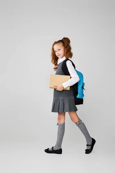 Linda colegiala con mochila y libro de longitud completa. — Foto de Stock