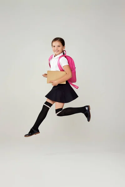 Schattig gelukkig schoolmeisje springen met rugzak — Stockfoto