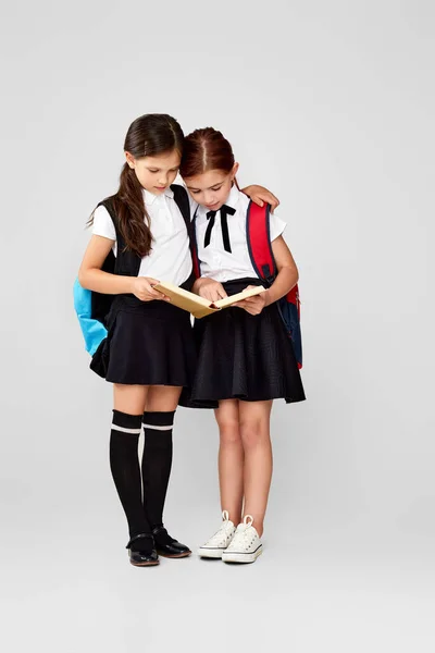 Twee gelukkig weinig vrolijk vrienden schoolmeisjes met rugzakken — Stockfoto