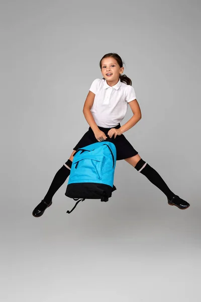 Bonito feliz estudante saltando para cima com mochila — Fotografia de Stock