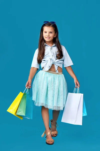 Feliz pequeño caucásico niña sostiene muchos bolsas de compras —  Fotos de Stock