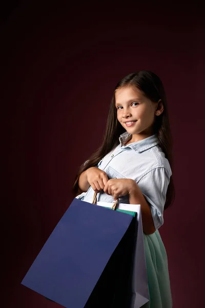 Gelukkig kind meisje houdt veel boodschappentassen — Stockfoto