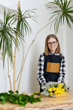 Çiçekçi kadın bir buket lale yapıyor..