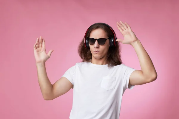 Man i solglasögon lyssnar på musik med hörlurar och danser — Stockfoto