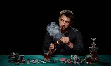 Yeşil masada poker oynayan sakallı kumarbaz.