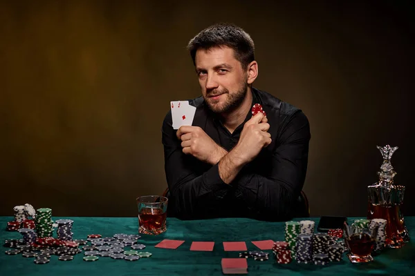 Bearded casino player man playing poker on green table