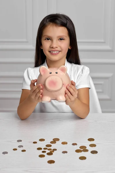 Menina criança com banco porquinho em casa — Fotografia de Stock