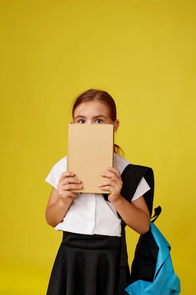 Aranyos boldog iskolás lány hátizsák és könyv — Stock Fotó