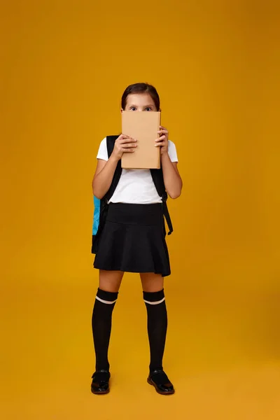 Sırt çantası ve kitap boyu uzun sevimli bir kız öğrenci.. — Stok fotoğraf