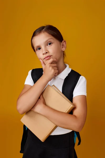 Schattig schoolmeisje met rugzak en boek volledige lengte. — Stockfoto