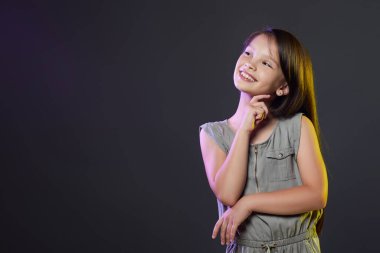 Siyah arka planda düşünceli küçük kız..