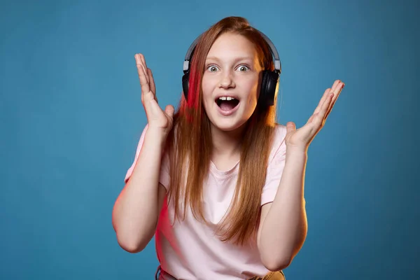 Schattig tiener meisje met rood haar in draadloze hoofdtelefoon — Stockfoto